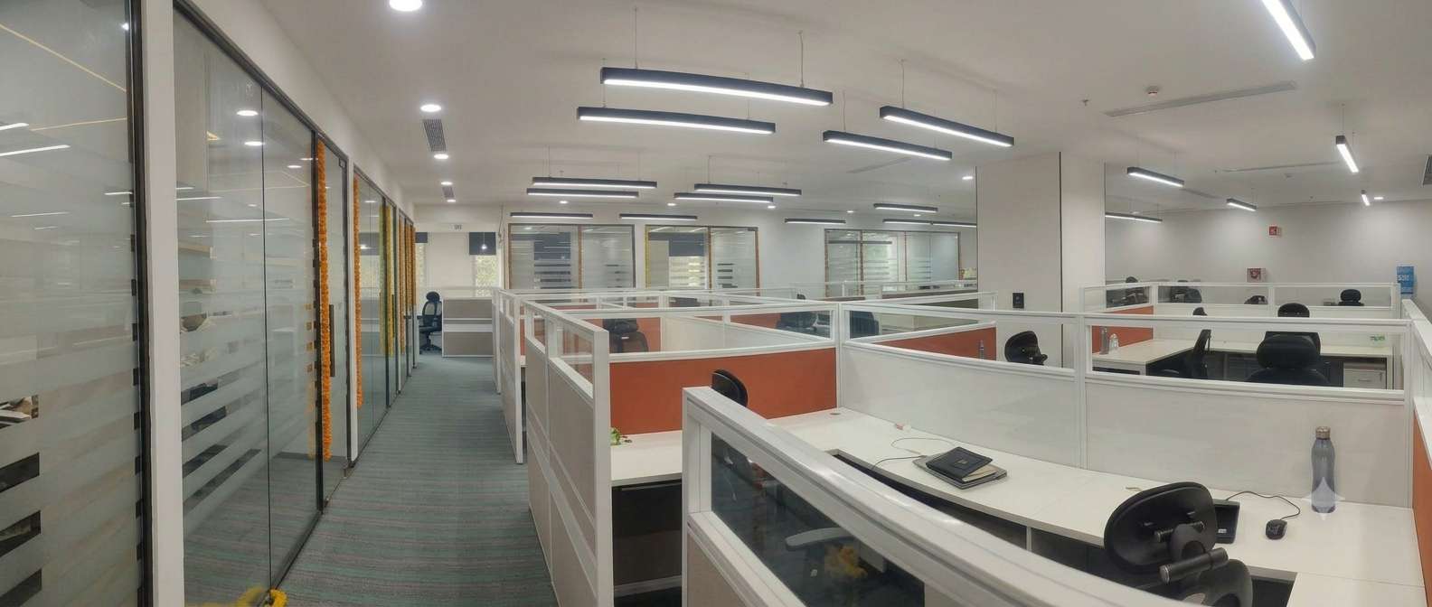 Zydus Wellness Gurgaon office — wide view of the minimal open-plan floor in warm neutral tones